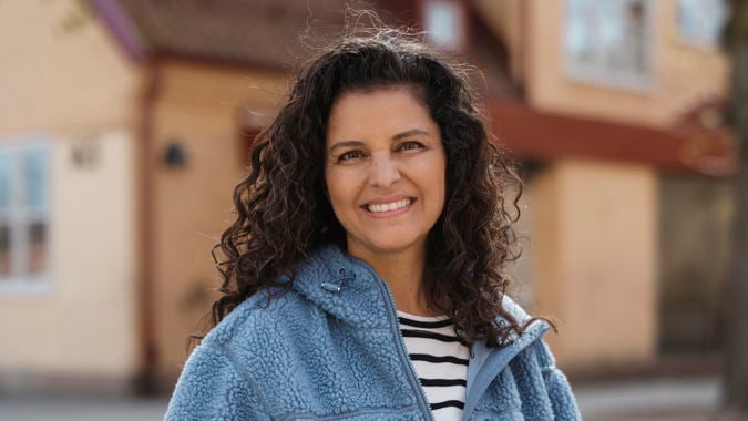 Leende kvinnlig förskollärare utomhus.