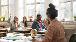 Gymnasielärare med elever under lektion.