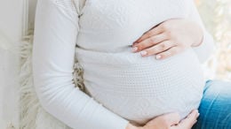 Havande kvinna med händerna på sin mage